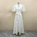 Dettaglio di un elegante abito lungo bianco stile francese con fiori 3D e bottoni dorati - Taglia S / Vestiti / Bianco