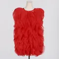 Detail view of a vibrant red sleeveless dress featuring layered ruffle stitching on a mannequin. - Red