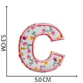 Écusson brodé lettre C avec de délicats motifs floraux roses sur tissu blanc - Lettre C