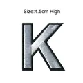 Iron-on embroidered letter K patch with silver grey fill and black border 4.5cm high - Letter K