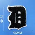 Vue détaillée d'un écusson brodé lettre D en chenille noire de 72mm sur 56mm taille - Lettre D (A001)