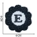 Close-up of a flower-shaped chenille embroidery patch with letter E, 6x6 cm size detail. - Letter E