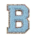 Dettaglio macro di una patch lettera B in ciniglia azzurra con bordo glitterato dorato - Lettera B / Celeste