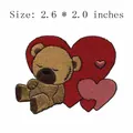 Brown teddy bear embroidery patch with red hearts, size 2.6 x 2.0 inches - Sitting Heart Teddy Bear (AFCA682)
