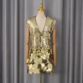 Close-up of the gold sequin texture and oversized metallic plate detailing on the hem - M / Dresses / Gold