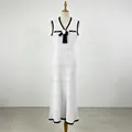 Detailansicht eines ärmellosen weißen Strickkleids mit schwarzen Rändern und 3D-Blumenakzent. - S / Kleider / Weiß