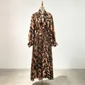 Elegant pleated skirt set with abstract pattern and pussy bow blouse on mannequin. - One Size / Top And Bottom / Brown