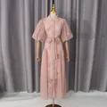 Vista completa di un abito rosa ricamato con maniche a sbuffo e cintura in vita annodata - Taglia M / Vestiti / Rosa