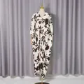 Close-up of a loose floral printed dress with V-neck and metal buckle detail. - One Size / Dresses / Black and White