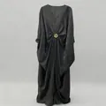Elegant black loose-fit maxi dress with V-neck, batwing sleeves, and golden sunburst buckle. - One Size / Dresses / Black