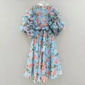 Detailed view of a vintage light blue dress with rose print and ruffled puff sleeves. - S / Dresses / Blue