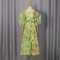 Close-up of vintage rose floral print dress featuring ruffled bubble sleeves and a waist bow - S / Dresses / Green