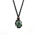 Close-up of natural green stone crystal pendant in black hand-woven macrame net bag - Green Aventurine