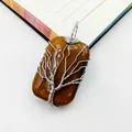 Macro view of handmade wire-wrapped tree of life pendant with brown tiger eye stone - Tiger's Eye