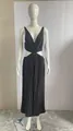 Detail of elegant black pleated maxi dress featuring waist cut-outs and deep V-neckline - Black