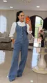 Model wearing a stylish blue denim wide-leg jumpsuit paired with a white puff sleeve shirt - S / Blue