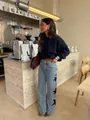 Woman in stylish light blue wide leg jeans with black star patchwork in a cafe setting. - S / Bottoms / Blue (Black Star)