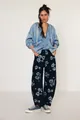 Stylish women's floral print barrel jeans in navy blue denim with a relaxed loose fit - Black Background Floral