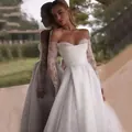 Detailed view of an elegant off-the-shoulder white wedding dress with long lace sleeves - US2 / Dresses / Ivory