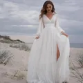 Elegant white V-neck wedding dress with long sleeves and split skirt on a beach. - US0 / Dresses / Pure White