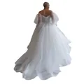 Detailed back view of an elegant off-the-shoulder white wedding dress with a long train - US2 / Dresses / White