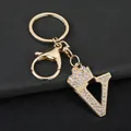 Macro detail view of a golden 'V' letter keychain charm with crown and sparkling rhinestones. - Letter V Decoration (YJ—310) / Gold