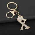 Detailed close-up of a gold-plated letter X keychain with crown and sparkling rhinestones - Letter X Decoration (YJ—310) / Gold