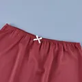 Close-up detail of a red high-waist skirt featuring a delicate white bow on waist - S / Burgundy