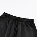 Detailed close-up showing the elastic drawstring waist of this elegant black satin midi skirt. - S / Bottoms / Black