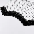 Close-up view of a stylish white polka dot skirt featuring elegant black lace trim details - S / Bottoms / White Polka Dot
