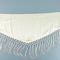 Detailansicht des eleganten cremefarbenen Satinstoffs und der feinen Fransen des Rocks. - S / Beige