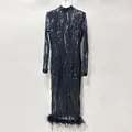 Detailansicht eines schwarzen Pailletten-Abendkleids mit Federsaum am unteren Rand. - S / Kleider / Schwarz