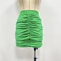 Detailed view of the bright green ruched mini skirt with shimmering rhinestone studs. - S / Bottoms / Green Mini Skirt
