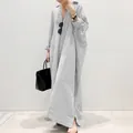 Elegant model wearing a black and white striped oversized maxi shirt dress in detail - S / Dresses / Gray