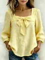 Detailed close-up view of elegant bow and square neckline on light yellow blouse - S / Tops / Yellow