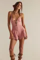Close-up detail of a pink denim romper with a deep V-neck and stylish halter strap design - Pink