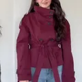 Macro view of a burgundy retro double-breasted short trench coat with a waist tie detail. - Burgundy