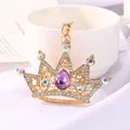 Detailed close-up of a sparkling crystal crown keychain with a purple teardrop gem - Purple