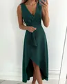 Elegant dark green sleeveless V-neck dress with ruffled high-low hemline on model - XS / Dresses / Dark Green