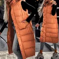 Long orange padded hooded vest for women in a stylish urban outdoor setting - S / Tops / Orange