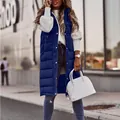 Sleeveless navy blue long quilted puffer vest for women styled with a white handbag in city - S / Blue