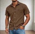 Detailed view of a brown men's short-sleeved denim shirt with front pocket and buttons - Brown