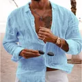 Detail shot of a light blue long-sleeved linen beach shirt for men in a coastal setting. - Sky Blue