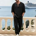 Set casual in lino nero da uomo con top con scollo a V e pantaloni larghi su un balcone estivo. - Nero