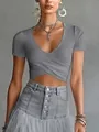 Close-up of grey V-neck cross-front crop top paired with high-waisted denim skirt. - XS / Tops / Gray