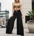 Vista completa di pantaloni neri a gamba larga con fiocco in vita su sfondo urbano chic - Nero