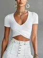 Close-up of white V-neck wrap crop top with slim fit and cross hem design - XS / Tops / White