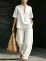 Vista completa del set minimalista bianco da donna con top a V e pantaloni larghi - Taglia S / Top E Pantaloni / Bianco