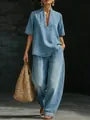 Modelo con conjunto azul minimalista de escote en V y pantalón ancho con bolso paja. - Azul claro