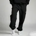 Detail of black oversized joggers and white socks on minimalist studio background setup - S / Bottoms / Black